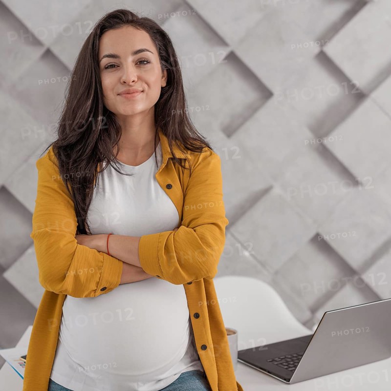 Pregnant woman posing with laptop home