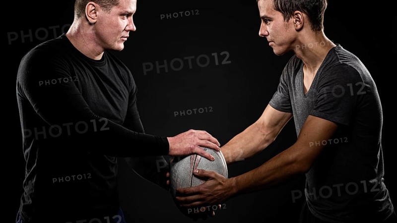 Side view male rugby players holding ball