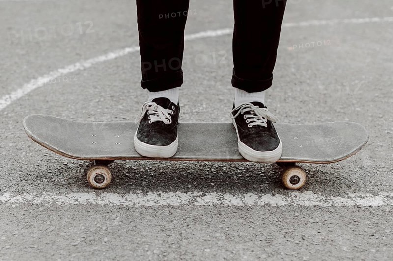 Skater girl legs standing her skateboard