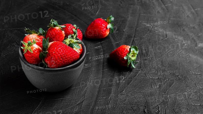 Strawberries bowl black table