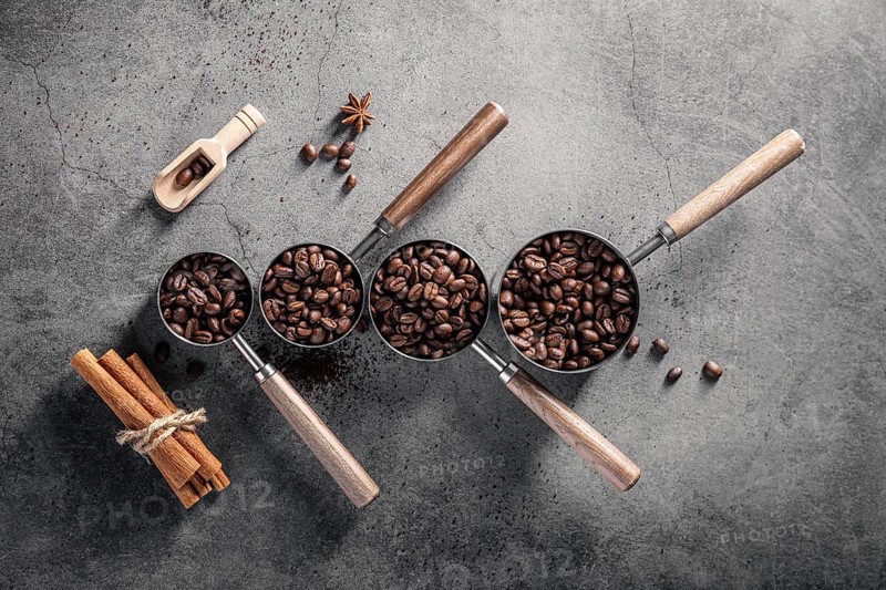 Top view coffee beans cups with scoop cinnamon sticks