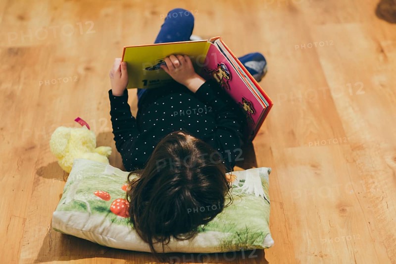 Unrecognizable girl reading toy book