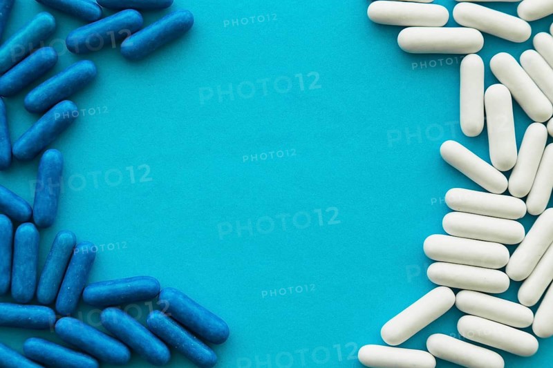 White blue candy capsules forming frame cyan background