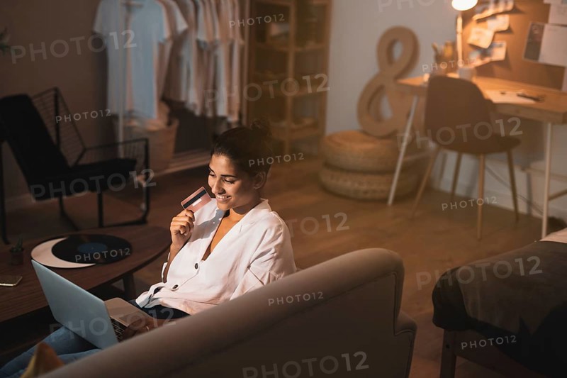Woman holding credit card working home