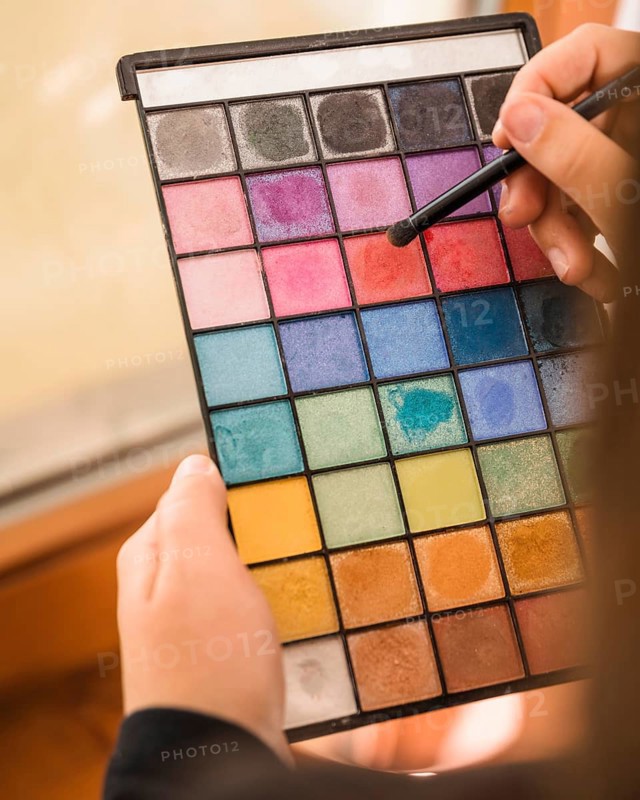 Woman s hand holding palette eye shadow powder