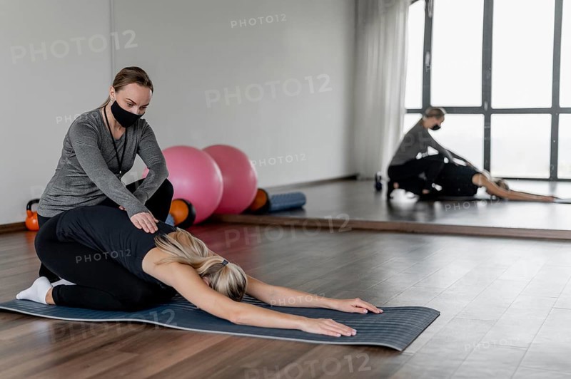 Workout with personal trainer stretching back