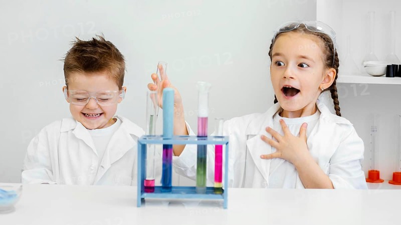 Young child scientists having fun doing experiments laboratory