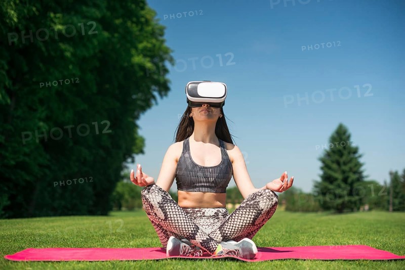 Athletic woman using virtual reality glasses outdoor