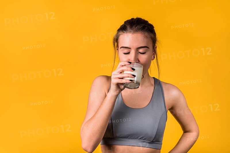 Attractive young woman sportswear drinking milk