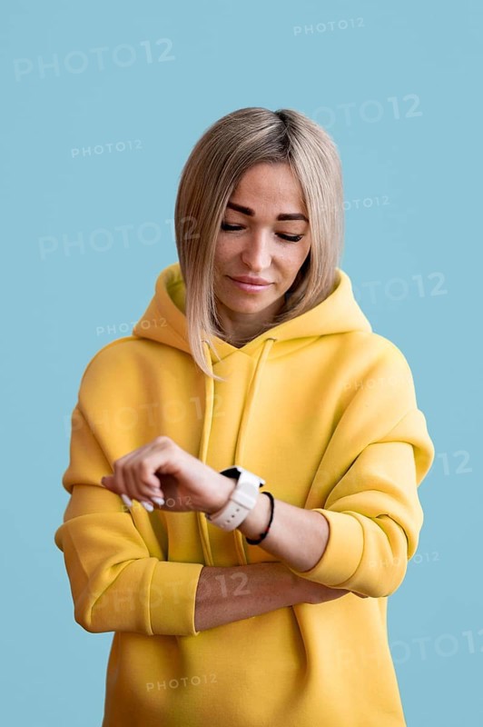 Blonde asian woman looking her smart watch