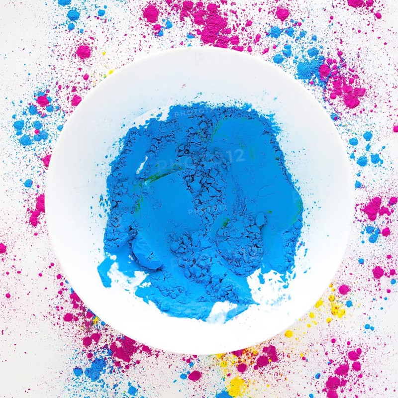 Blue holi color powder white bowl white backdrop