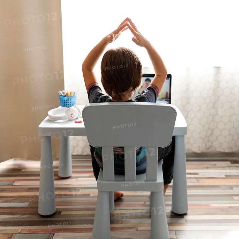 Boy talking with his teacher gesturing online school