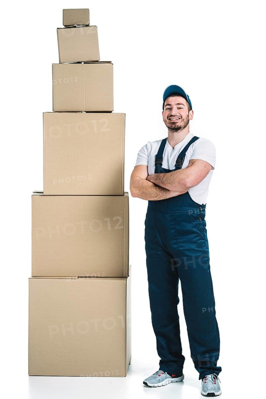 Cheerful courier near stack boxes