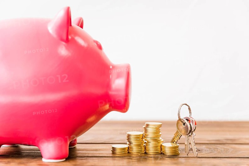 Close up pink piggybank near stacked coins key