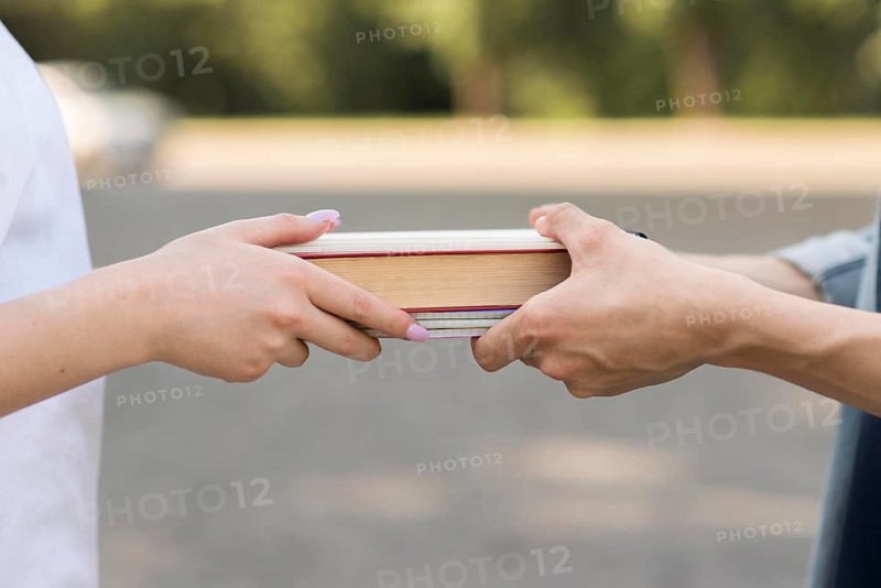 Close up students exchanging book