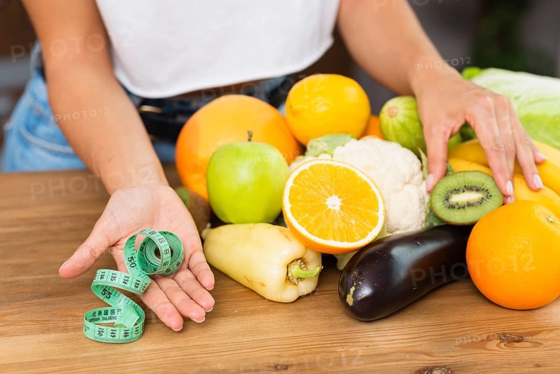 Close up woman with fruits measuring tape