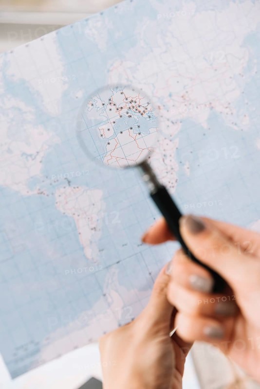Female tourist searching places travel map through magnifying glass