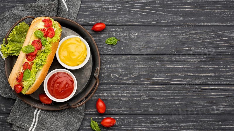 Flat lay hot dog with sauce bowls