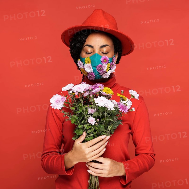 Front view woman with mask holding flowers