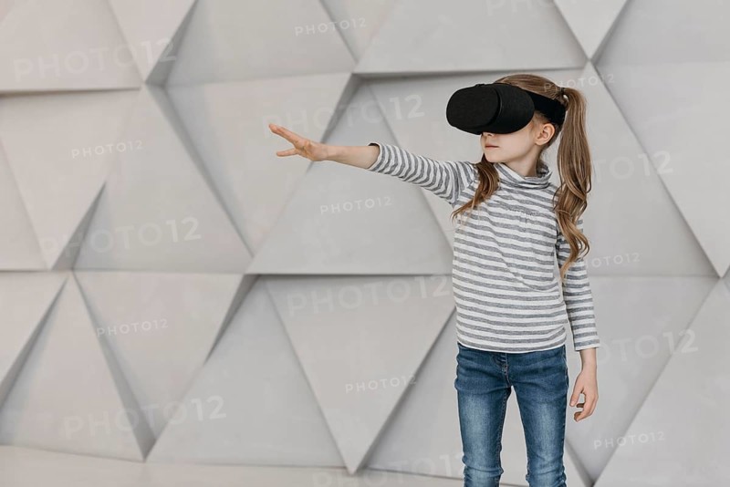 Girl wearing virtual reality headset stretching her hand