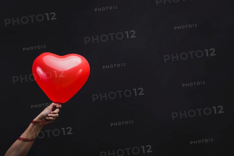 Hand holding heart shaped balloon