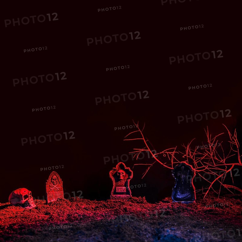 Headstones skull illuminated by red light ground