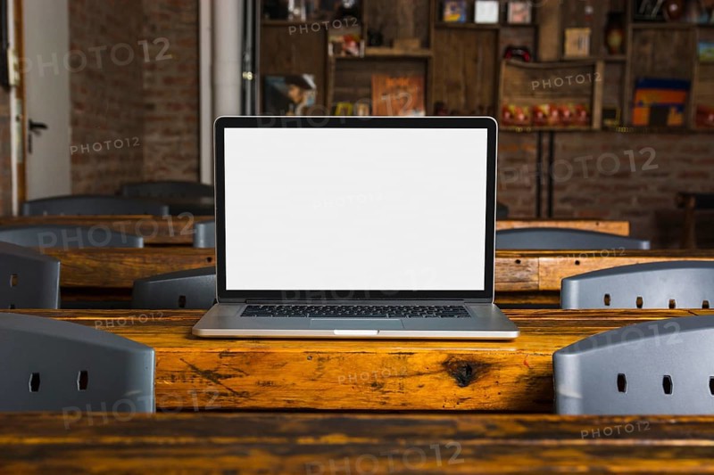 Laptop with white display screen wooden table caf