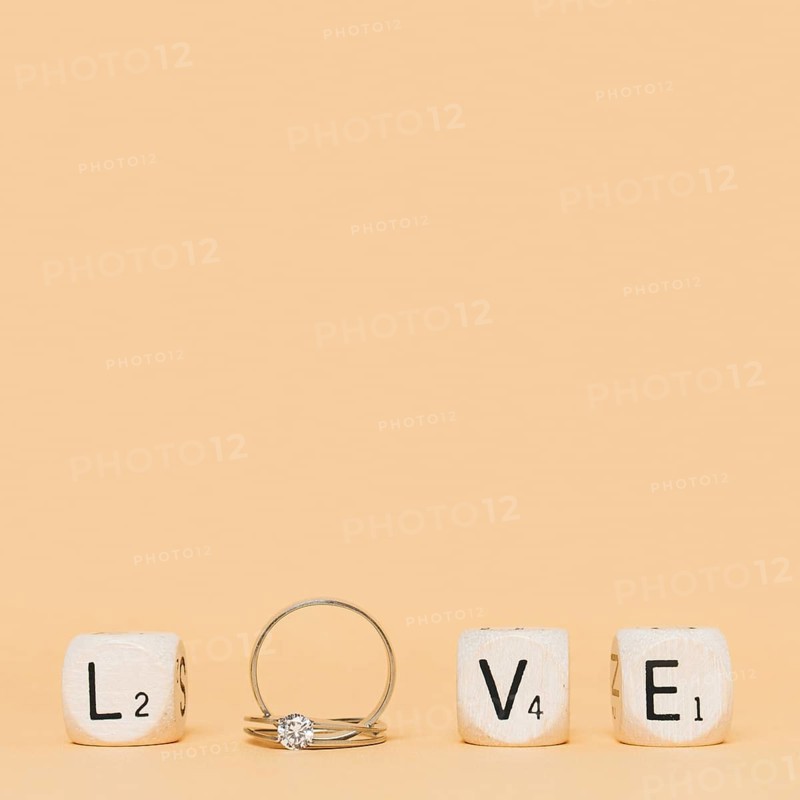 Love letter made with wedding diamond rings cubes cream background