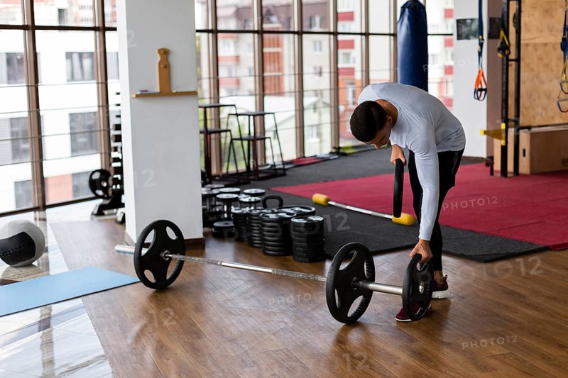 Man placing weight plates bar