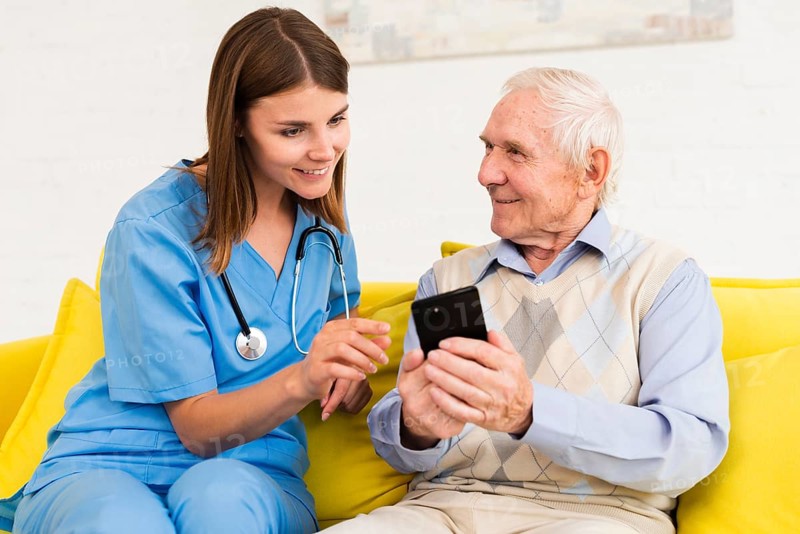 Old man showing s phone nurse