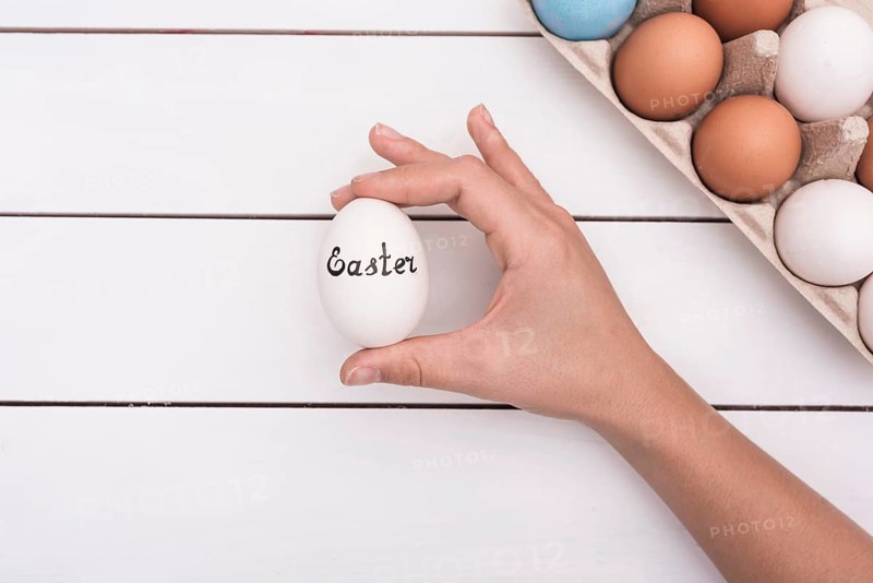 Person holding egg with easter inscription