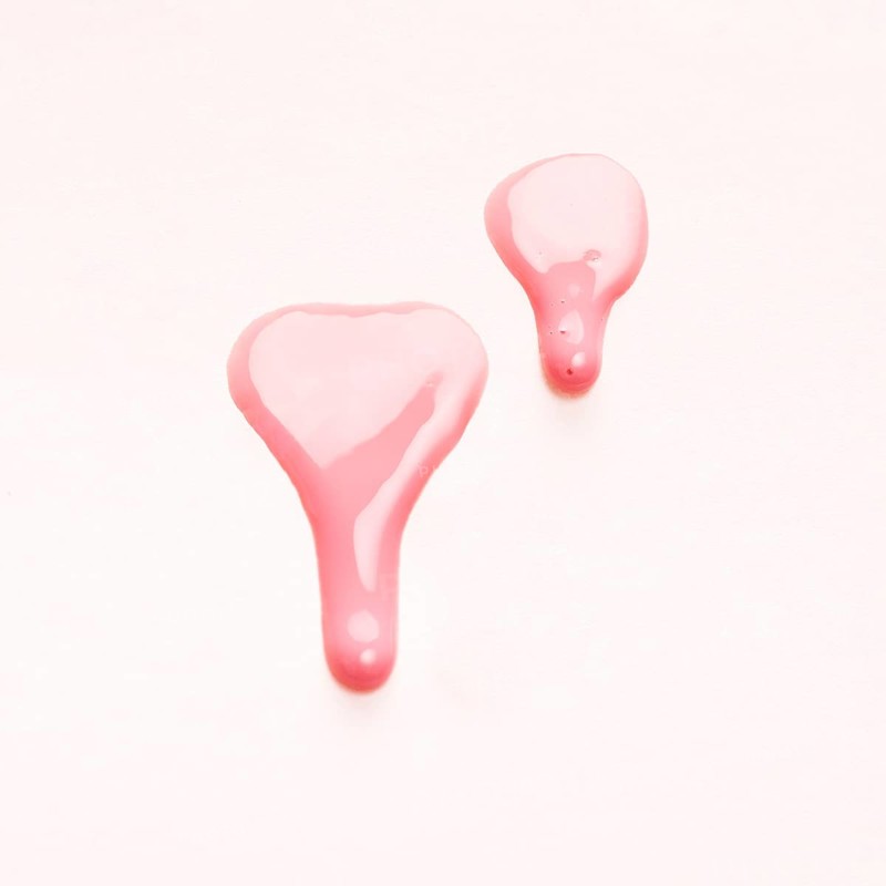 Pink nail polish drops sample isolated white surface