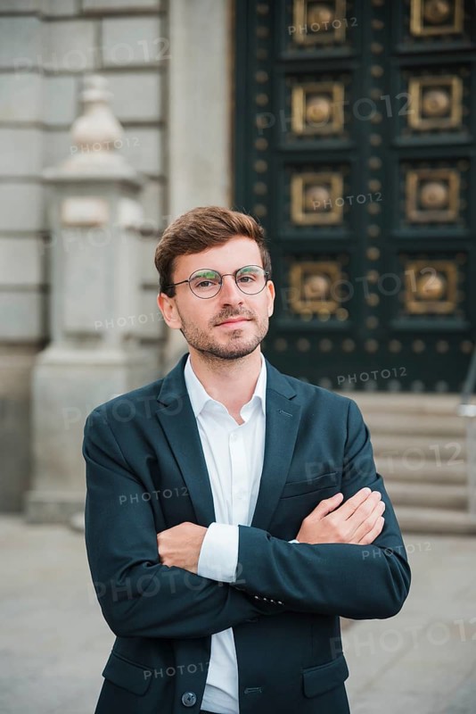 Portrait confident young businessman with his arms crossed