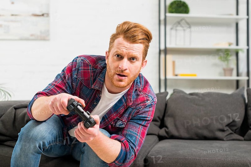 Portrait serious man playing video game with joystick home