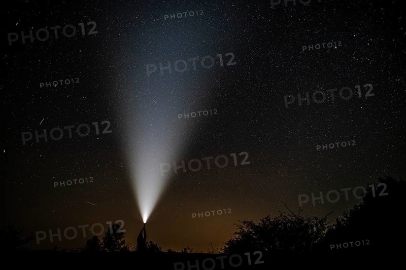 Shooting stars seen near flashlight held by man