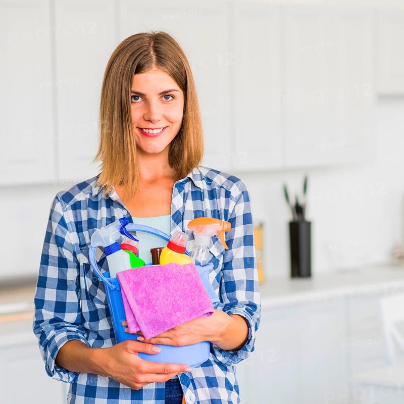 Smiling housewife holding cleaning equipment hands
