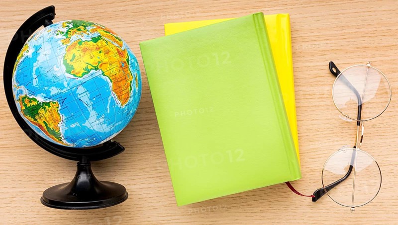 Top view back school supplies with glasses globe