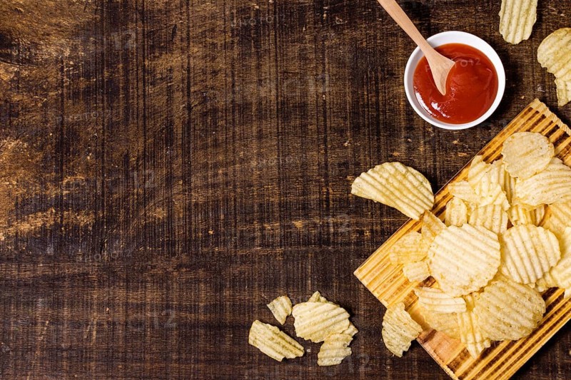 Top view potato chips with ketchup copy space