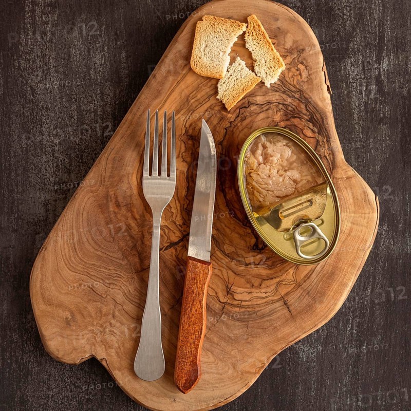 Top view tuna can wooden board with cutlery