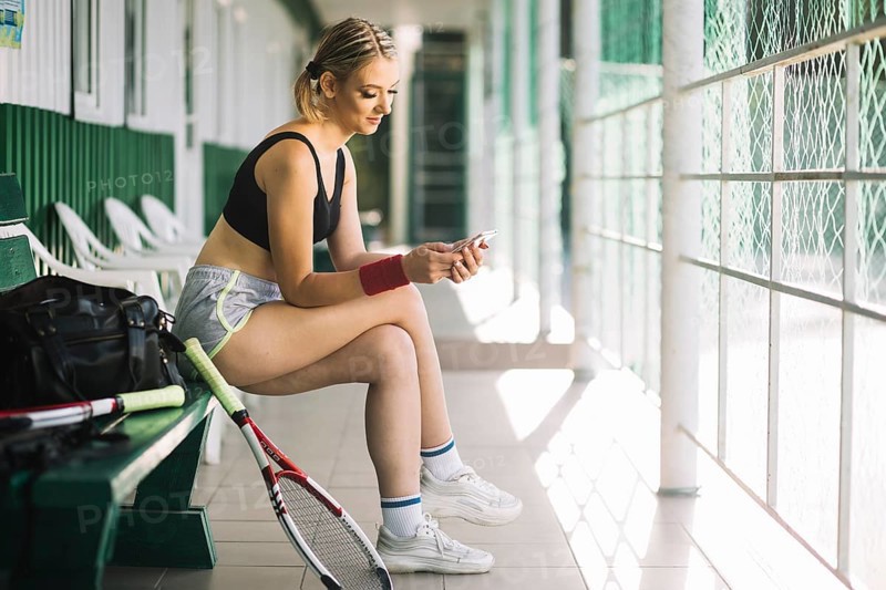 Woman tennis player checking her phone