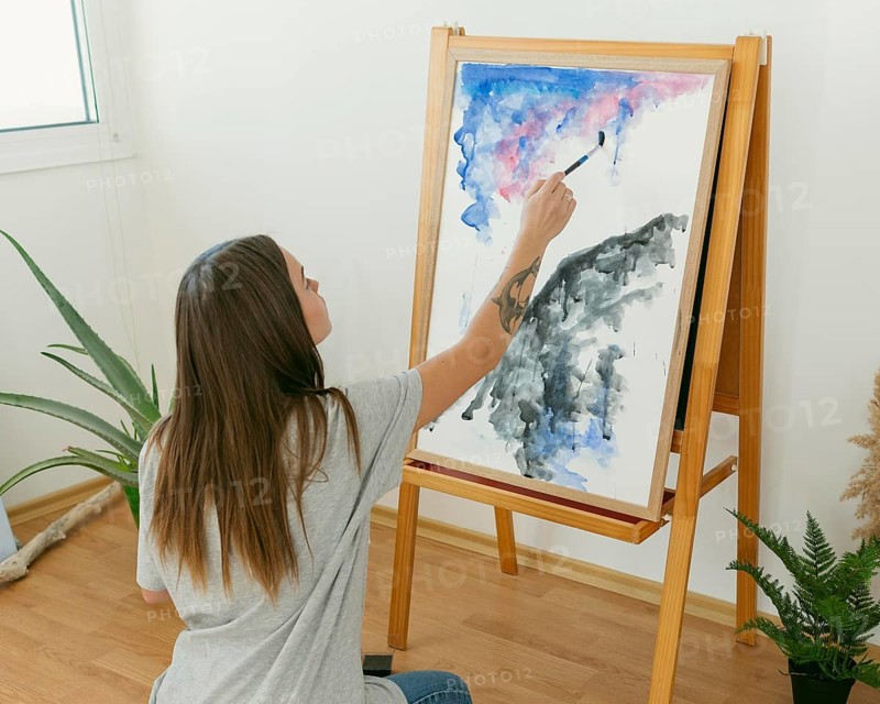 Artist woman painting canvas from shot