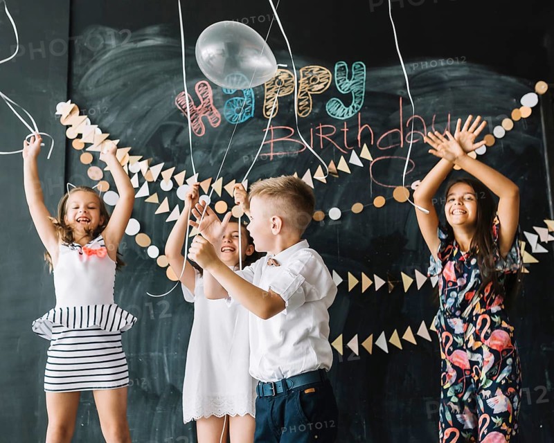 Cheerful kids releasing balloons birthday party