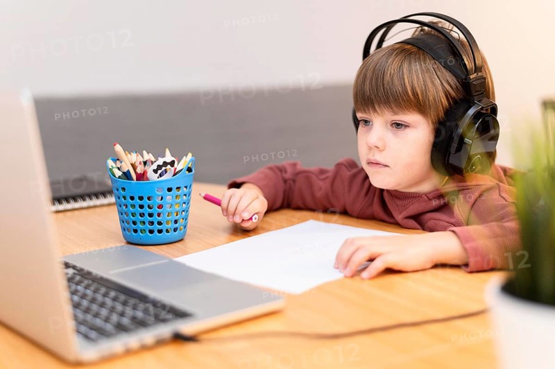 Child wearing headphones attending online school
