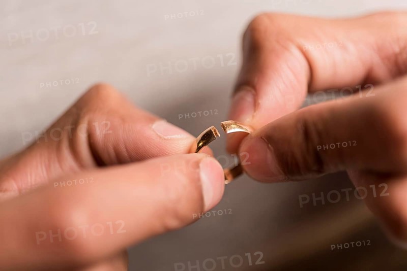 Close up hands holding broken ring