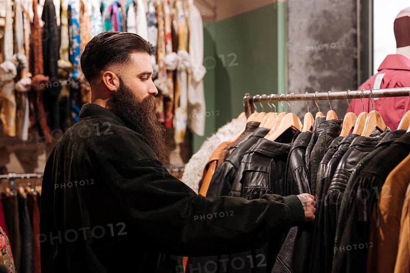 Close up man looking leather jacket rail clothing shop