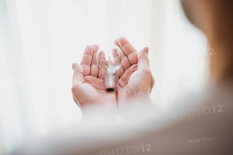 Close up man s hand holding light bulb