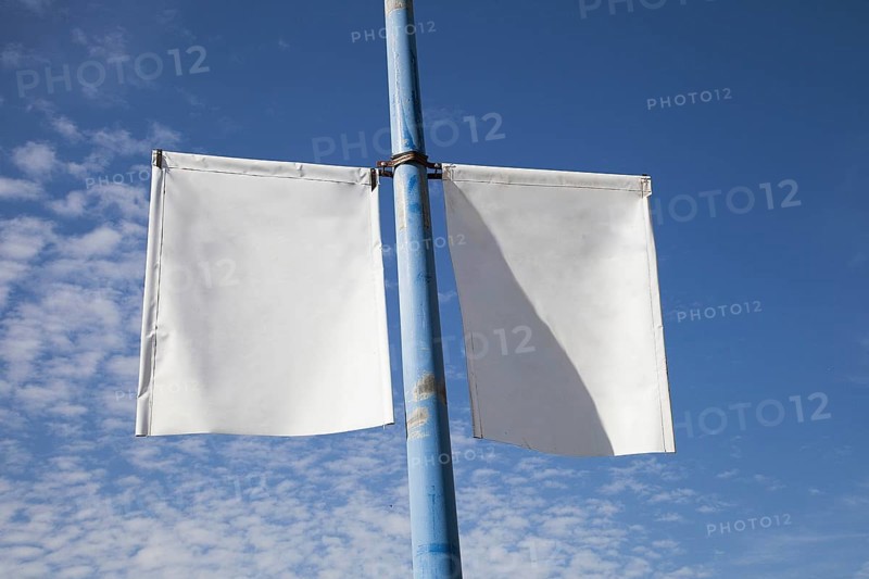 Close up white lamp post banner poster against blue sky