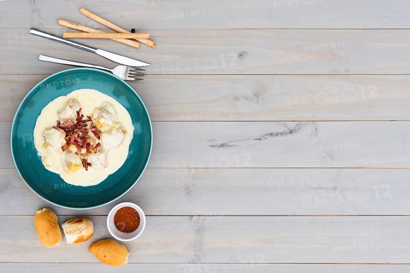Creamy tasty italian pasta ceramic plate with bread meal wooden background
