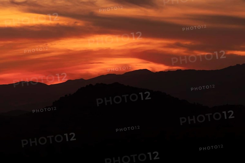 Dark yellow clouded sky with black mountains