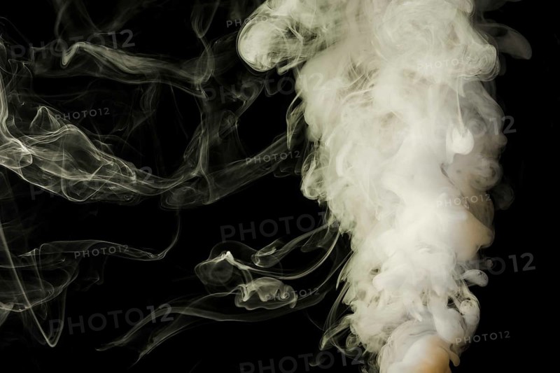 Dense fluffy puffs white smoke black background